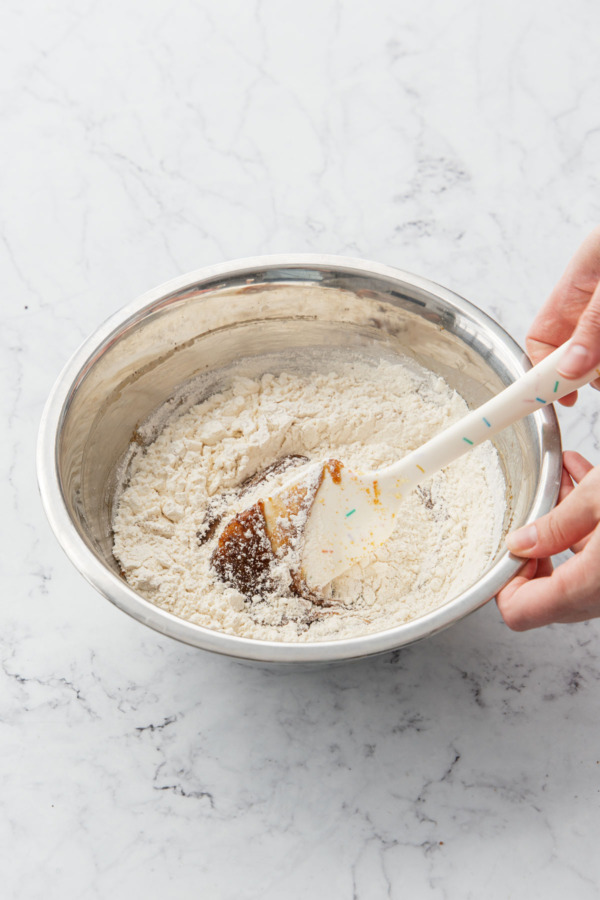Mixing in dry ingredients with a spatula.