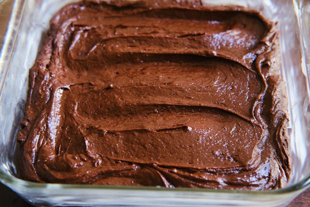 Brownie batter in a glass baking dish before baking