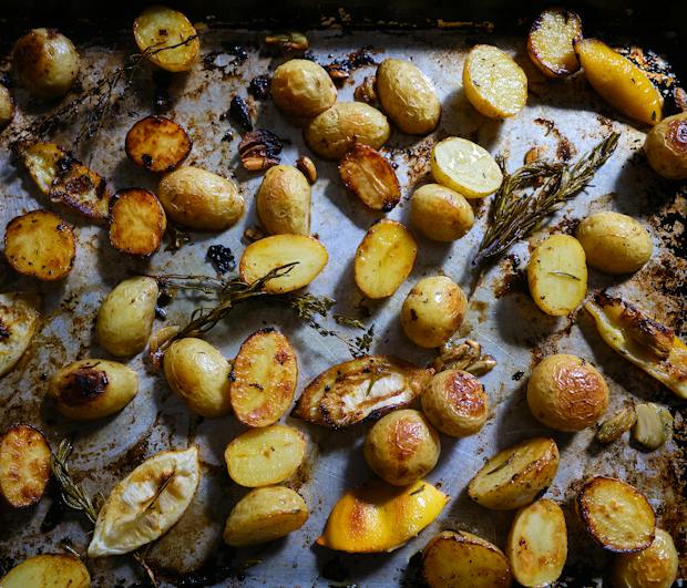 Ingredients for lemon roasted potatoes on a sheetpan and tossed with olive oil after baking